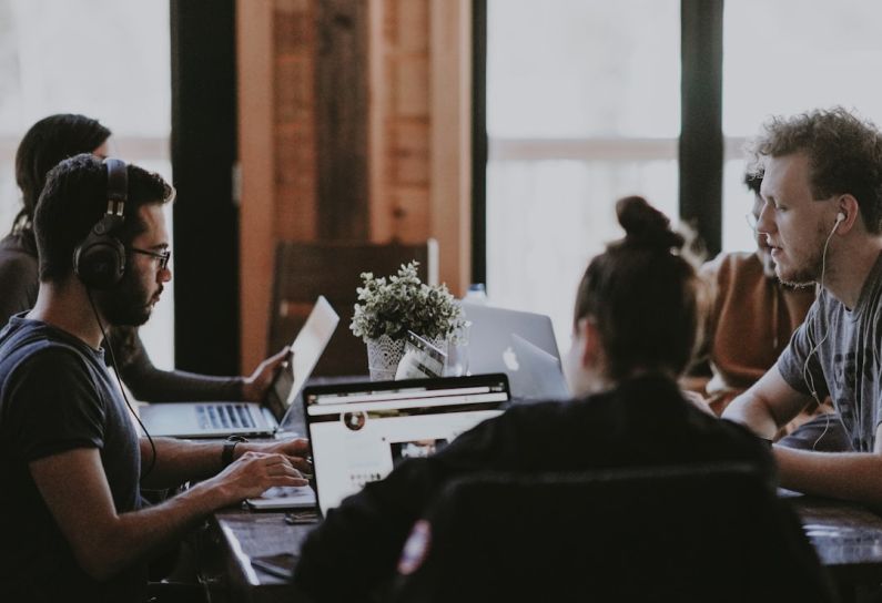 Employee - selective focus photography of people sits in front of table inside room