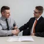Employee - two men facing each other while shake hands and smiling