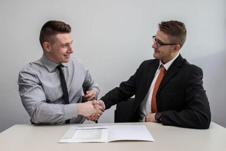 Employee - two men facing each other while shake hands and smiling