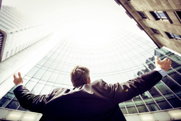 Employee - low-angle photography of man in the middle of buidligns