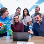 Employee - woman in maroon sweater using laptop
