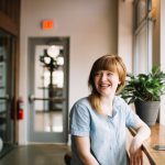 Employee - woman sitting in front of brown wooden table