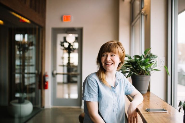 Employee - woman sitting in front of brown wooden table