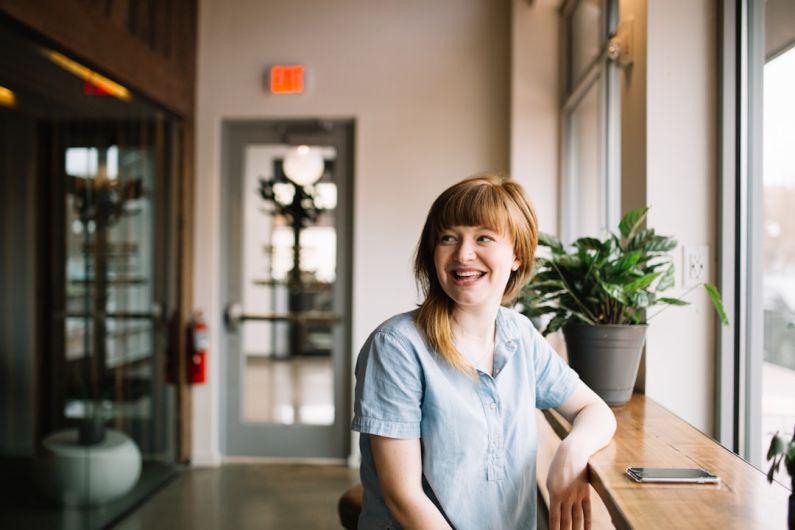 Employee - woman sitting in front of brown wooden table