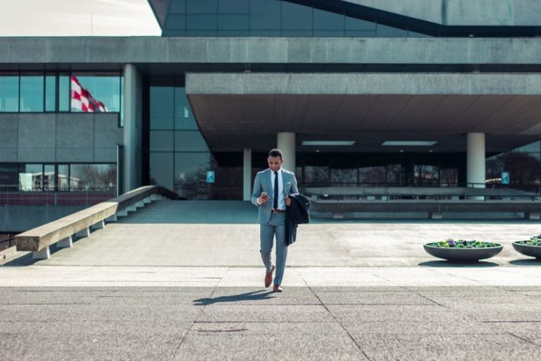 Leadership Business - man walking while holding black coat