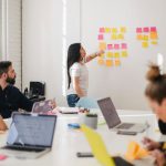 Marketing - woman placing sticky notes on wall
