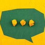 Communication - three crumpled yellow papers on green surface surrounded by yellow lined papers