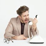 Communication - man holding telephone screaming