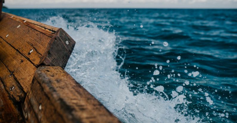 Dropshipping - Detail of shabby wooden boat sailing in blue sea and splashing water in summer