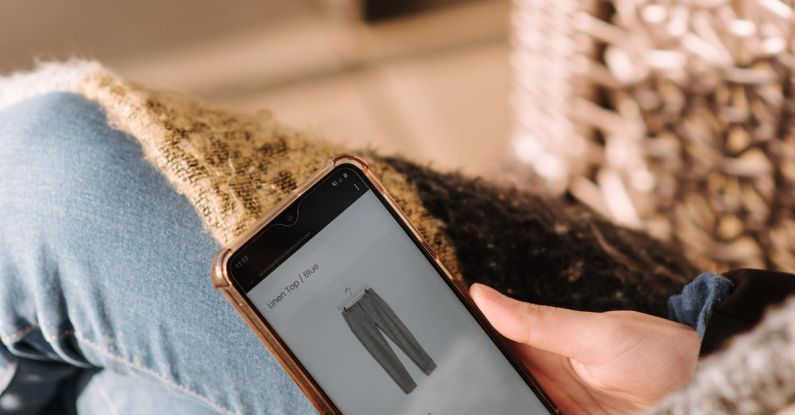 Cross-Border E-commerce - High angle of unrecognizable woman sitting on chair and choosing clothes in internet shop using mobile phone