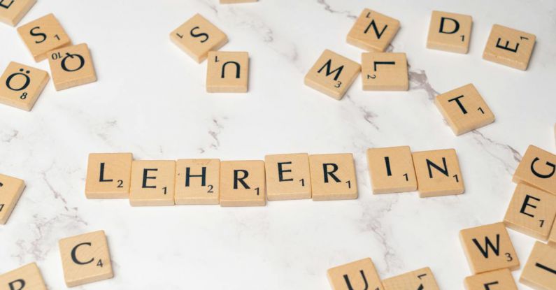 Mentorship - Scrabble tiles spelling lehrerin on a white marble surface