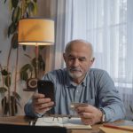 Sale - Man Holding Smartphone and a Credit Card