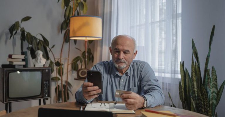 Sale - Man Holding Smartphone and a Credit Card