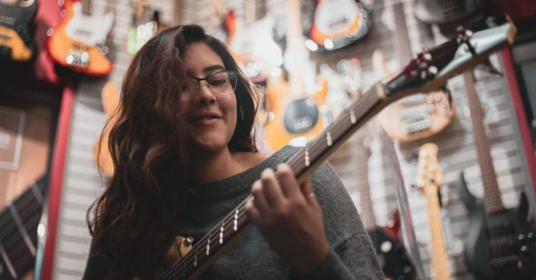 Talent - Shallow Focus Photo Of Woman Playing Guitar