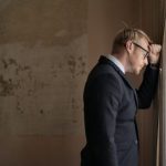 Crisis - Desperate evicted male entrepreneur standing near window