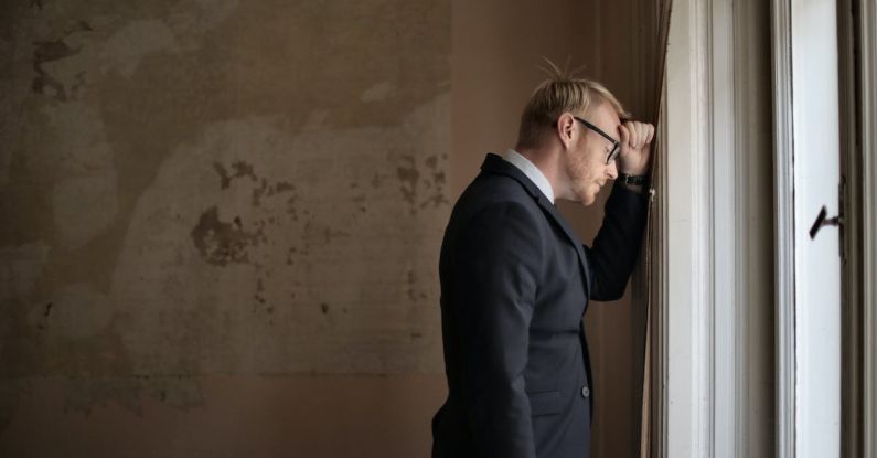 Crisis - Desperate evicted male entrepreneur standing near window