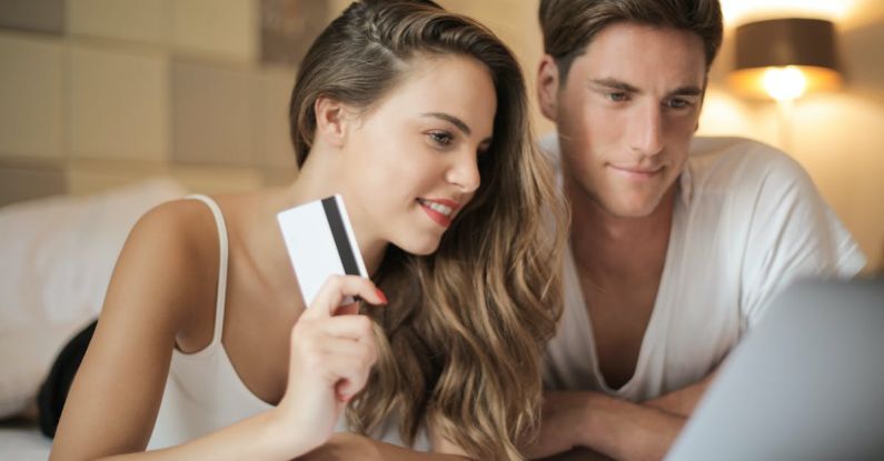 Customer Relationships - Cheerful couple making online purchases at home