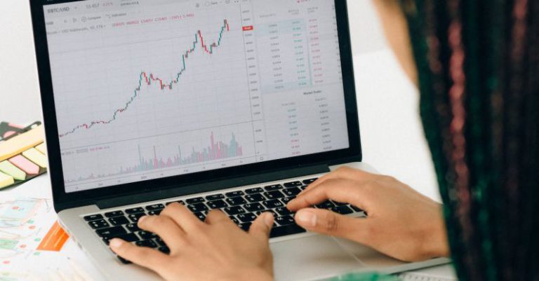 IPOs - Person Using Macbook Pro on White Table